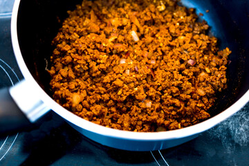 plant-based food, vegan rehydrated textured vegetable protein with seasoning before adding tomato sauce