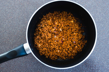 plant-based food, vegan rehydrated textured vegetable protein with seasoning before adding tomato sauce