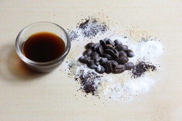 Coffee beans sugar and creamer on wood background