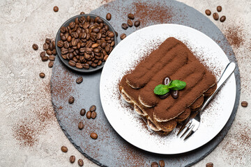 Classic tiramisu dessert on ceramic plate on concrete background