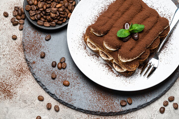 Classic tiramisu dessert on ceramic plate on concrete background