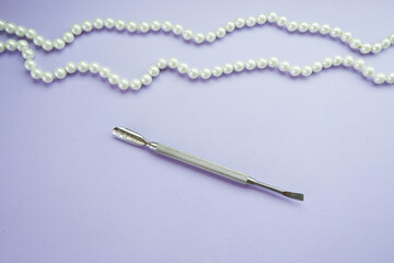 Manicure tool pusher on a lilac background