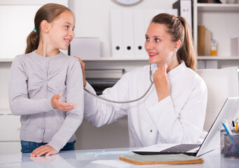 Portrait of little child with young medical worker in medical center