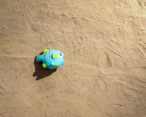 Fototapeta na wymiar toy fish on the sand