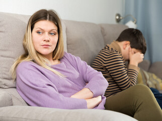 Upset mother and offended son crying after quarrel in domestic interior
