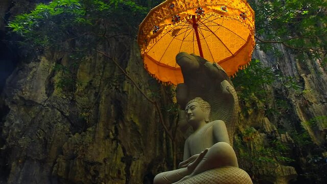 Incense smoke rising to a stone statue and Chatra or golden parasol in Vajrayana Buddhism
