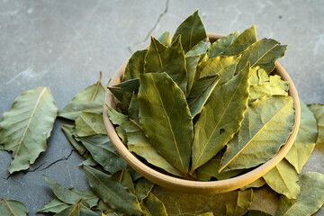 Bay leaves in a clay dish on a concrete worktop