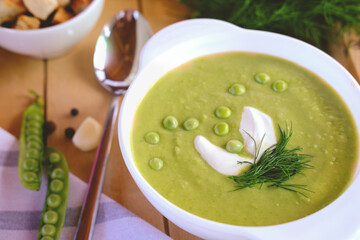 green pea puree soup. pea cream soup with dill and sour cream. summer soup with green peas and...