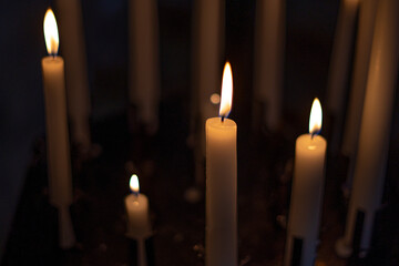 Candle flame close-up in church for religious ritual. Black background. High quality photo