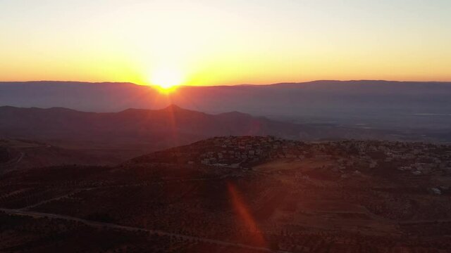 Majestic sunset aerial view over south Jerusalem mountains. Silhouette landscape with sunlight flare behind the horizon mountains of judea and samaria Binyamin settlements west bank.