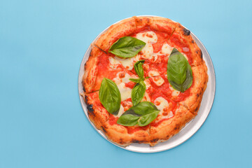 Pizza Margherita with mozzarella cheese and fresh tomato garnished with basil leaves. Traditional Italian cuisine.