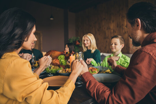Portrait of nice attractive idyllic big full family meeting hold hand praying sitting around table eating homemade festal dishes meal luncheon at modern loft industrial wooden interior house apartment