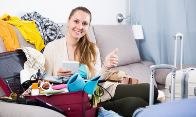 Smiling woman buying hotel or ticket in internet using laptop and card at home