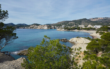 Obraz premium Calo de Sa Romana, a rocky beach some the size of a melon, in the background Platja Gran de Torà and Platja Palmira. Peguera, municipality of Calviá, Mallorca