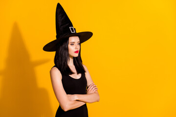 Profile photo of pretty lovely young sorceress lady crossed arms self-assured look empty space want turn everyone frog wear black headwear dress isolated bright yellow color background