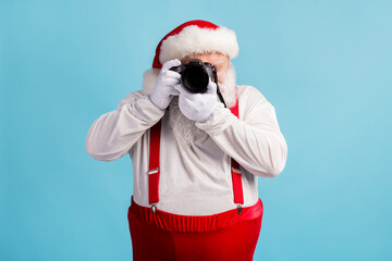 Fototapeta na wymiar Portrait of his he nice attractive white-haired Santa holding in hands professional camera shooting taking making photo cadre focus event isolated bright vivid shine vibrant blue color background