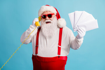 Fototapeta na wymiar Portrait of his he nice attractive cheerful cheery overweight white-haired Santa holding in hand mail gifts wish list calling talking Eve Noel isolated bright vivid shine vibrant blue color background
