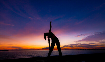 Silhouette woman make practice yoga and meditation for healthy with twilight sky background