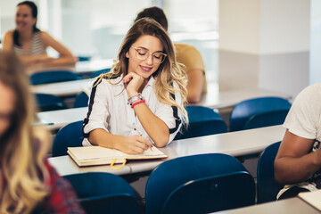 Concentrating students sitting at the college lecture hall