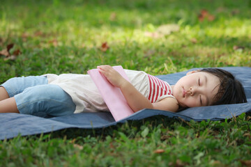 本を持ったままお昼寝する女の子