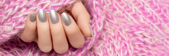 Female hand with silver nail design. Silver nail polish manicure. Advertising banner template.