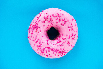 sweet pink donut on a blue background. Sweet dough products.