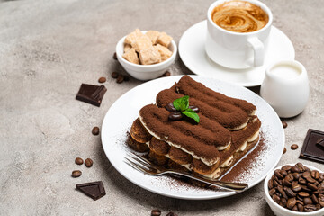 Classic tiramisu dessert, cup of coffee, sugar and milk on concrete background