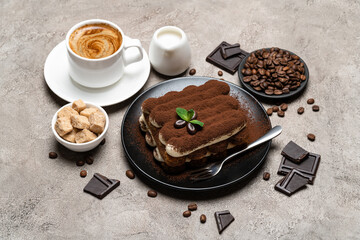 Classic tiramisu dessert, cup of coffee, sugar and milk on concrete background