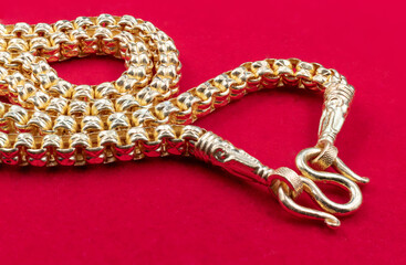 Golden necklace placed on the red velvet floor