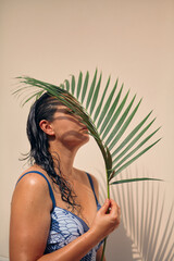 Portrait of girl in swimsuit with palm branch