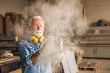Craftsman at workshop removing sawdust
