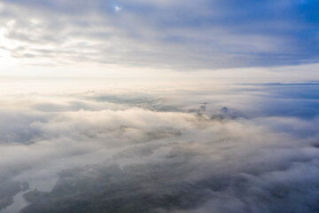 Fototapeta premium Photo from a fog drone on the ground. Fog below, clouds above! You can see the river and the area of the city.