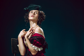 Dreamful. Young woman as Anna Karenina isolated on dark blue background. Retro style, comparison of eras concept. Beautiful female model like literature character, great, old-fashioned.