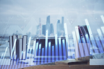 Obraz premium Stock market graph on background with desk and personal computer. Double exposure. Concept of financial analysis.