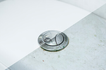 Photo of the button for draining water from the toilet tank before and after washing