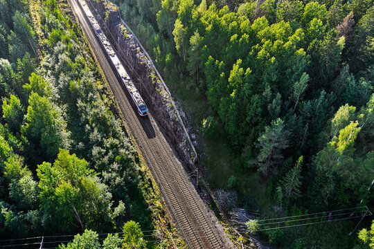 The high-speed commuter train moves on the railroad in the countryside in Espoo, Finland. Aerial view picture.