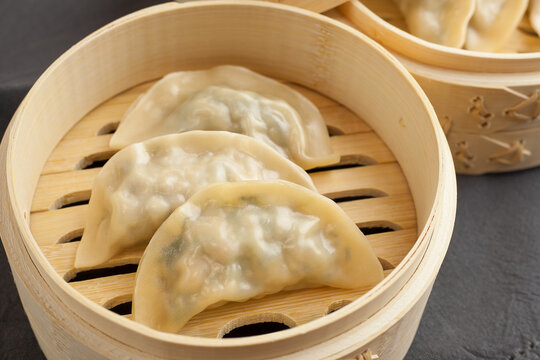 Close up of delicious Korean mandu or gyozas served on a wood steamer cooked.