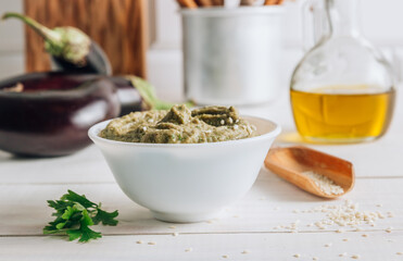 Traditional arabian eggplant dip baba ganoush on white wooden table