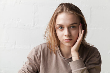 Young beautiful serious blond girl, close-up portrait