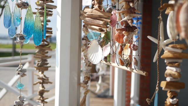 Nautical style hanging seashells decoration, beachfront blue wooden holiday home, pacific coast, California USA. Marine pastel interior decor of beach house in breeze. Summertime sea wind aesthetic