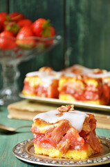 Cake with rhubarb and strawberries on a green wooden background