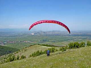 Paraglider launching wing in a meadow	