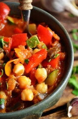 Stew with vegetables in a rustic bowl on a wooden background