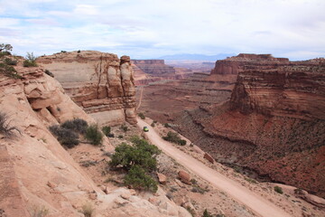 A green Off-Road Vehicle driving on Exploring trail at island in the sky in Canyonlands National Park Utah, USA
