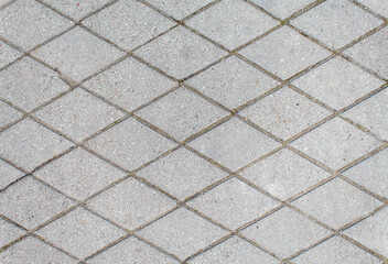 road paved with rhombus sidewalk tiles. texture of light gray bricks.