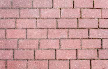 road paved with brown sidewalk tiles. texture of light gray bricks.