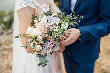 happy bride and groom hugging with a bouquet in their hands