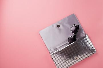Elegant women envelope bag with silver metallic sequins and fancy sunglasses
