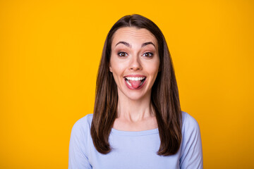 Fototapeta premium Closeup photo of attractive pretty cheerful lady good mood sticking tongue out mouth teasing boyfriend fooling around wear casual shirt isolated vibrant yellow color background