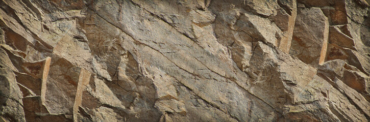 Brown stone background. Rock texture. Mountain surface. Close-up. Stone wall. Wide banner with grunge texture and copy space for your design.